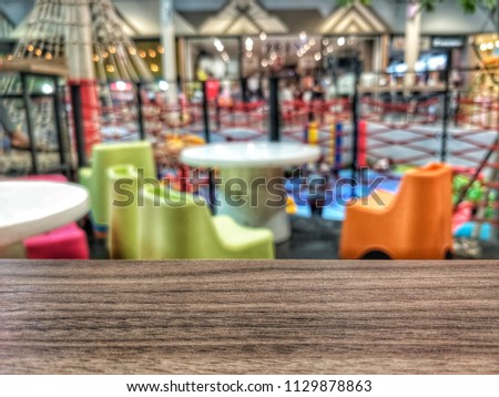 Wood board empty table in front of indoor playground blurred background