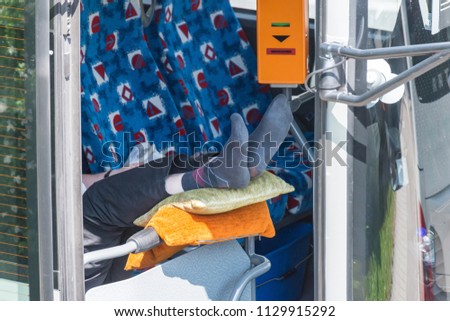 Bus driver takes a break and puts his feet up Royalty-Free Stock Photo #1129915292