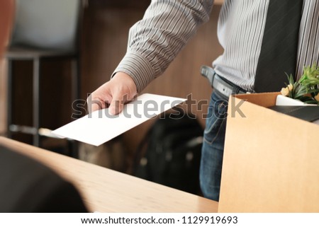 Business man sending resignation letter to boss and Holding Stuff Resign Depress or carrying cardboard box by desk in office