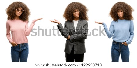 African american young woman wearing different outfits smiling cheerful presenting and pointing with palm of hand looking at the camera.