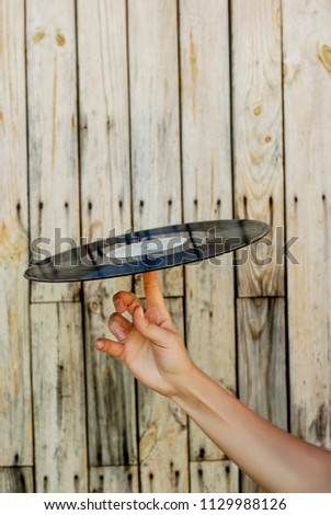 Female hand holding vinyl record over wooden background