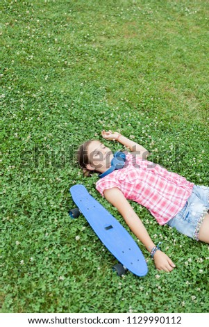 joyful girl having fun in the park with her skateboard 