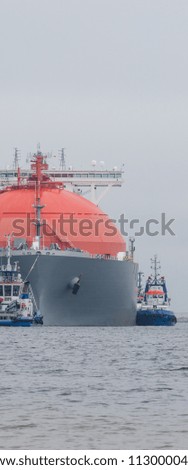 GAS CARRIER - A great tanker towed by a tugboat
