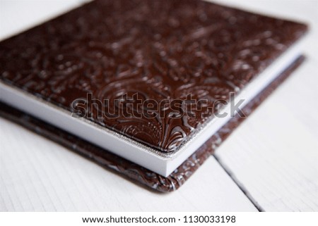 On the wooden surface is a closed book with a brown leather cover. The concept of education and science.