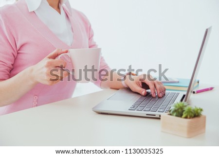 Woman's hands with keyboard. Office worker workplace with a cup of coffee, laptop and business daily book. Office worker routine