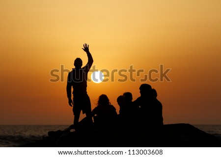silhouette of group in sunset at beach