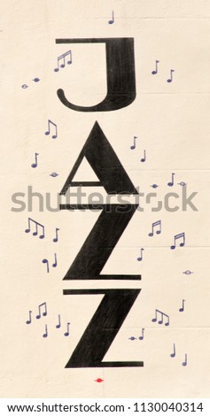 The word Jazz written upside down on a white wall with music notes on the site