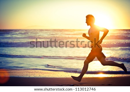 Man running on the beach at sunset - female version in portfolio Royalty-Free Stock Photo #113012746