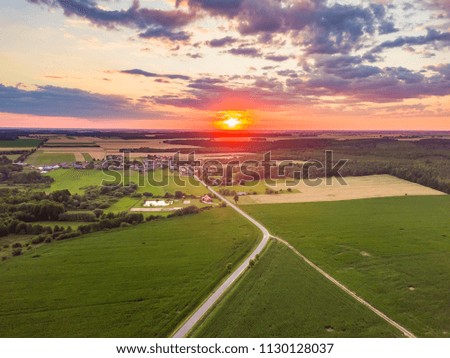 Beautiful summer fields landscape from drone. Sunset over fields and village.
