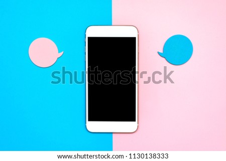 Flat lay design with blank on a smart phone with bubbles for text messages. Minimalist blue and pink background. 