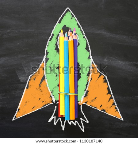 Back to school concept. rocket sketch and pencils over classroom blackboard background