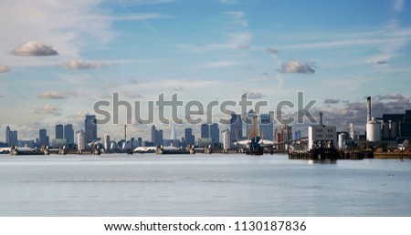 London Skyline seen from South Bank. Overlooking Canary Wharf with Thames Barrier.