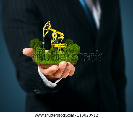Extraction of oil. Pump jack on men's hand Royalty-Free Stock Photo #113020912