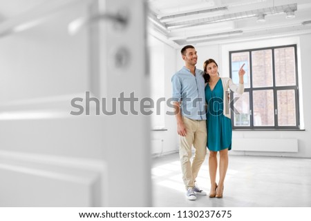 mortgage, people and real estate concept - happy couple hugging at new home Royalty-Free Stock Photo #1130237675