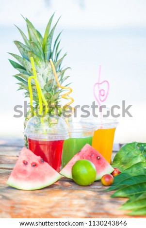 Fresh healthy juices, fruit, pineapple, watermelon on the background of the sea. Summer, rest, healthy lifestyle Copy space