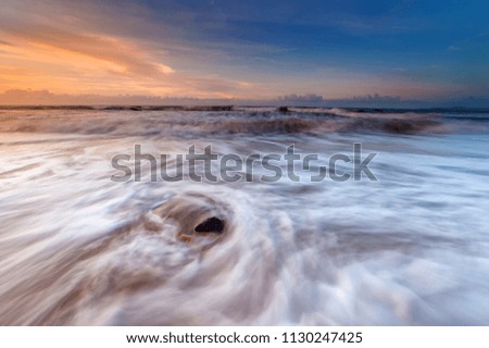 sunset seascape during heavy monsoon wind. heavy sea wave. soft focus due to slow shutter to show the waves movement.