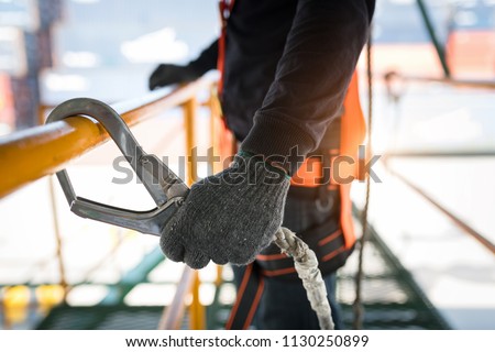 Construction worker wearing safety harness and safety line working at high place Royalty-Free Stock Photo #1130250899