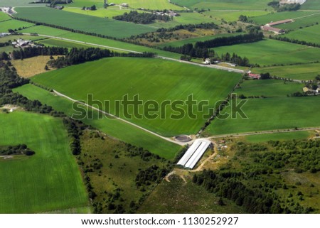 The surface of the earth from an airplane. Fields, meadows, farms. Route Oslo-Stavanger. Selective focus.