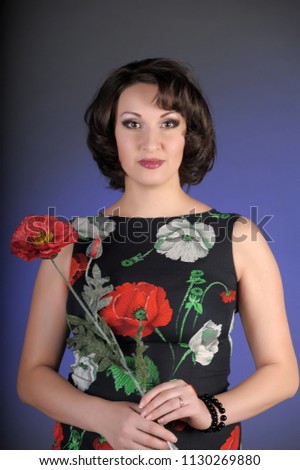 beautiful brunette with red poppy in studio