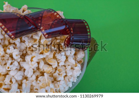 Popcorn, photo negative, on a green background, close-up Top view. Concept pastime,