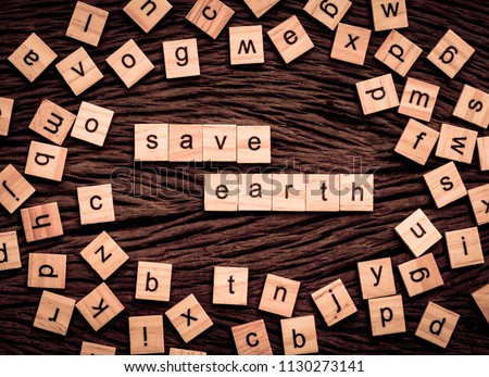 Save Earth word written cube on wooden background. Vintage concept.