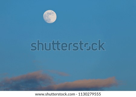 Full moon glows bright in the night blue sky at early of spring.