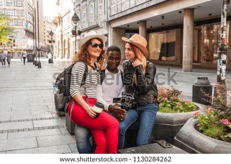 Three tourists taking pictures while resting, sitting, in the center of Belgrade