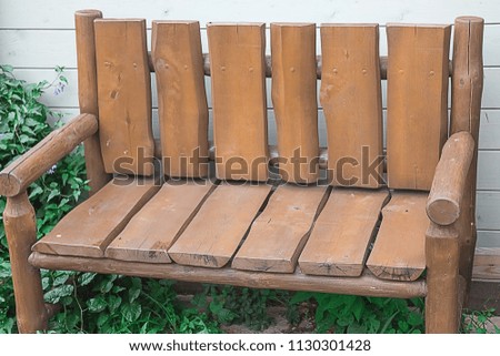 Photo of a bench for rest in a city park on an avenue of paving stones