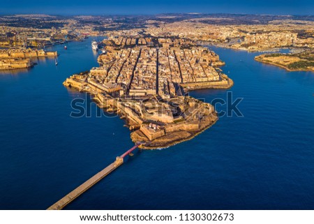 Valletta, Malta - Aerial skyline view of the sea entrance of Valletta with Breakwater Lighthouse, Grand Harbor, Birgu, Senglea and Manoel Island at sunrise