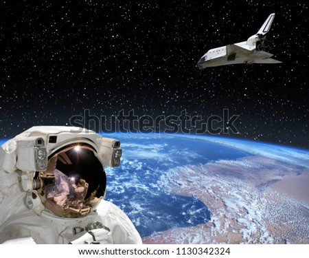 Astronaut looking at shuttle that flies in space. The elements of this image furnished by NASA.
