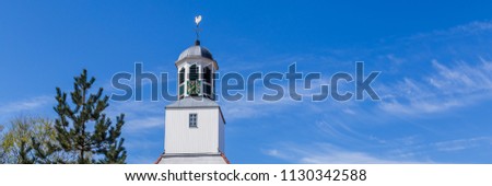 White wooden chruch tower with clock in Den Burg Texel, Netherlands