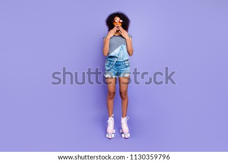 Oops! Portrait of impressed frustrated girl in eyewear riding on pink roller skates holding two hands near mouth isolated on bright violent background retro vintage student concept