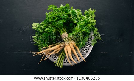 Fresh green parsley. Root parsley. On a wooden background. Top view. Copy space. Royalty-Free Stock Photo #1130405255