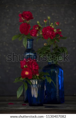 red roses and blue glass bottles