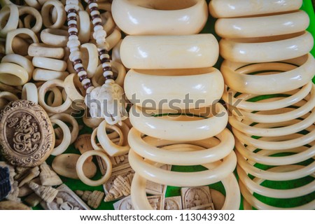 Souvenirs and amulets carved from Ivory for sale at Thai-Cambodia border market. Royalty-Free Stock Photo #1130439302