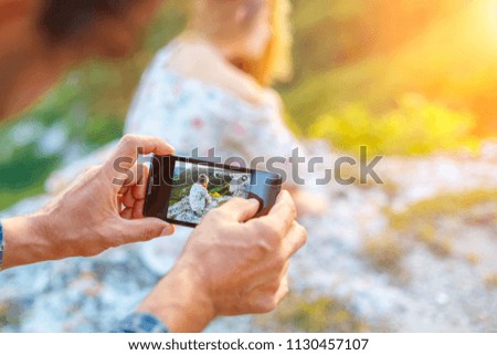 hands holding the phone and taking pictures of the girl on the phone