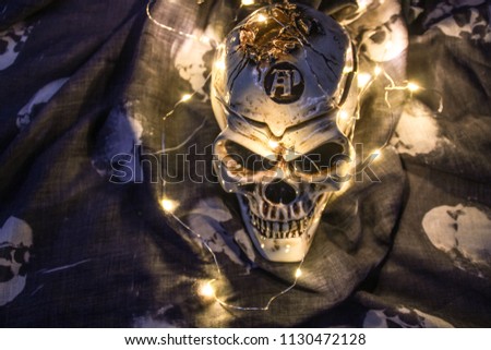 Helloween skull in the dark with a garland.
