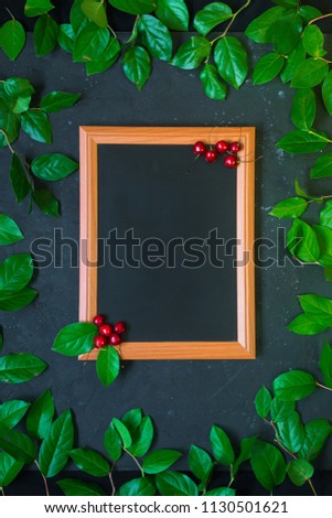 Summer natural frame with black chalkboard on dark background with red cherries berries fruits in corner, fresh dew wet effect live nature concept announcement blank empty mock up frame