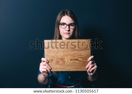 
beautiful woman with a wooden board in hands. concept of woodworking industry, furniture manufacturing.