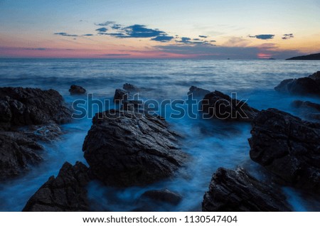 Beautiful landscape and nature photo of sunset at Adriatic Sea in Croatia Europe. Nice colorful outdoors image. Calm, peaceful picture of ocean, rocks and sky at dusk evening.