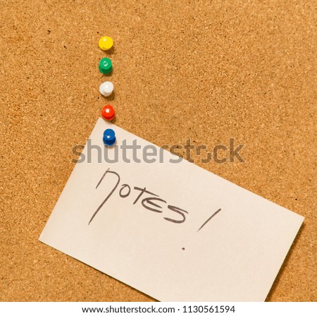 notes on the cork board- adhesive note with blue pin on cork board