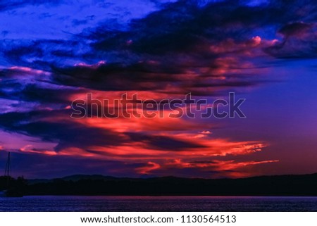 A striking inspirational crimson and cobalt blue coloured stratocumulus cloudy coastal sunrise. Queensland, Australia.