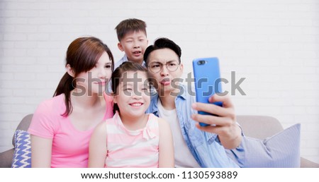 family take phone and selfie happily at home