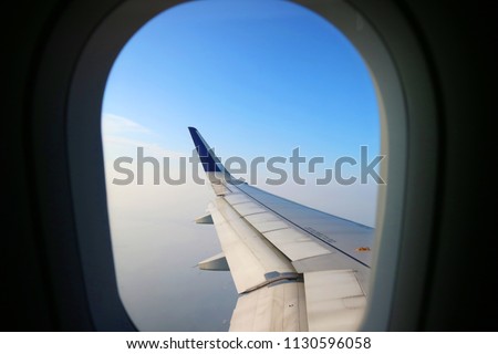 view from airplane window with clouds and blue sky