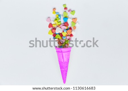 Purple Ice cream cone with  colorful small hearts shape on white background. Minimal love concept. Flat lay. Top view.