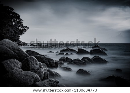 Beautiful seascape with motion of waves on the sea at Surin Beach, Phuket, Thailand. Tropical beach paradise holiday, dramatic beach background. Black and white taken.