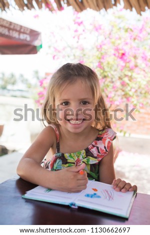 Adorable little girl drawing artwork top view on crayons in a notebook, Baby healthy and preschool concept