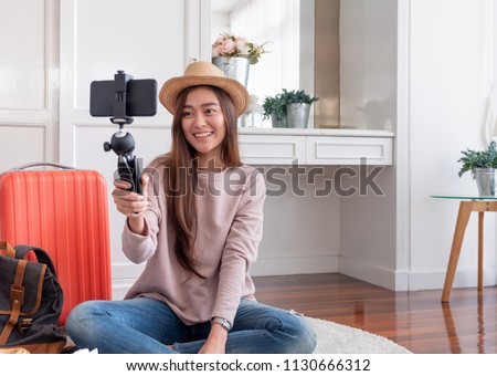Asian young female blogger recording vlog video with mobile phone live streaming when travel.online influencer on social media viral concept Royalty-Free Stock Photo #1130666312