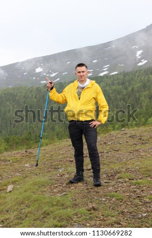 A hyperactive, handsome young man is engaged in tourism and climbs to the top of the mountain "Konzhakovsky stone", Russia, the North Urals, Sverdlovsk region. Purposeful guy in the mountains