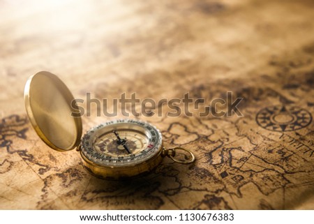 Old gold compass on ancient map background ,vintage tone with copy space for text.